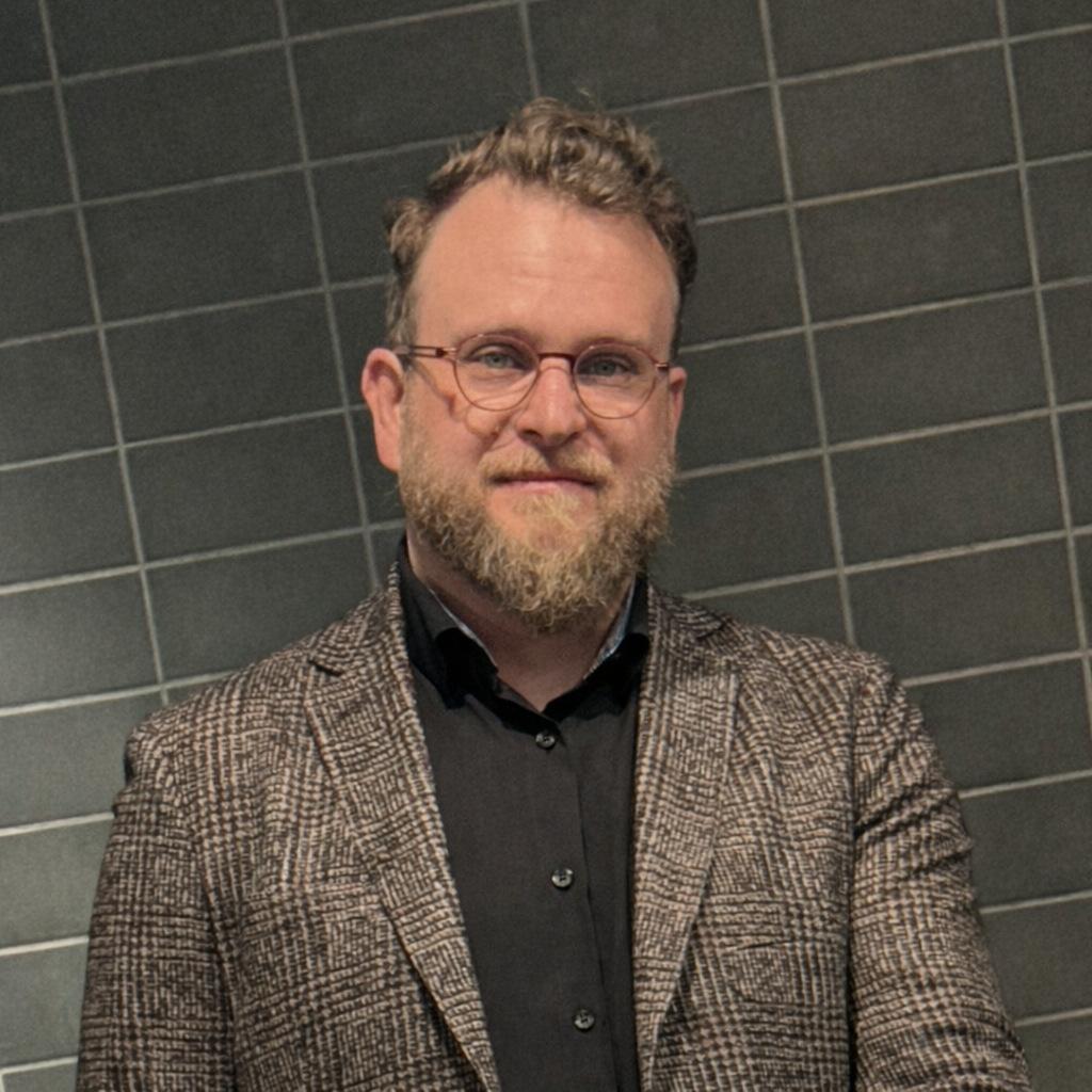 Ryan Yepsen in a blazer and glasses